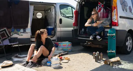 Foto: Kristian G. Selon To jenter og to campervans. En sitter på bakken, en bak i bilen.